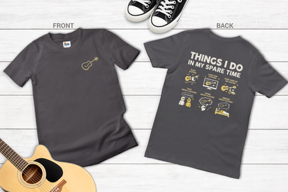 Gray t-shirt with front and back designs on a wooden surface with a guitar and sneakers.