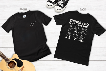 Black t-shirt with text and graphic on a wooden surface with a guitar.
